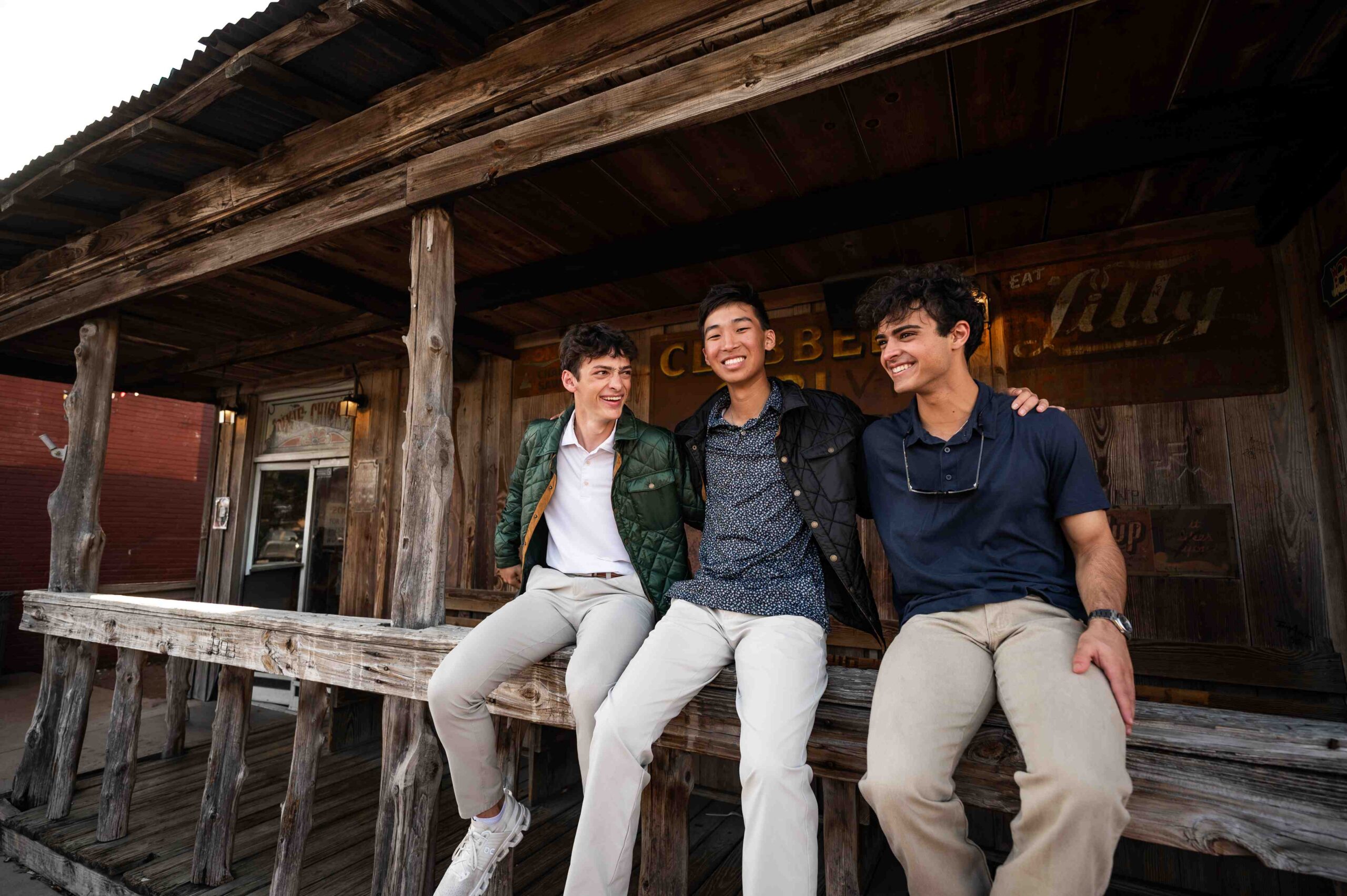 three smiling young men on a porch near honcho in college station tx scaled
