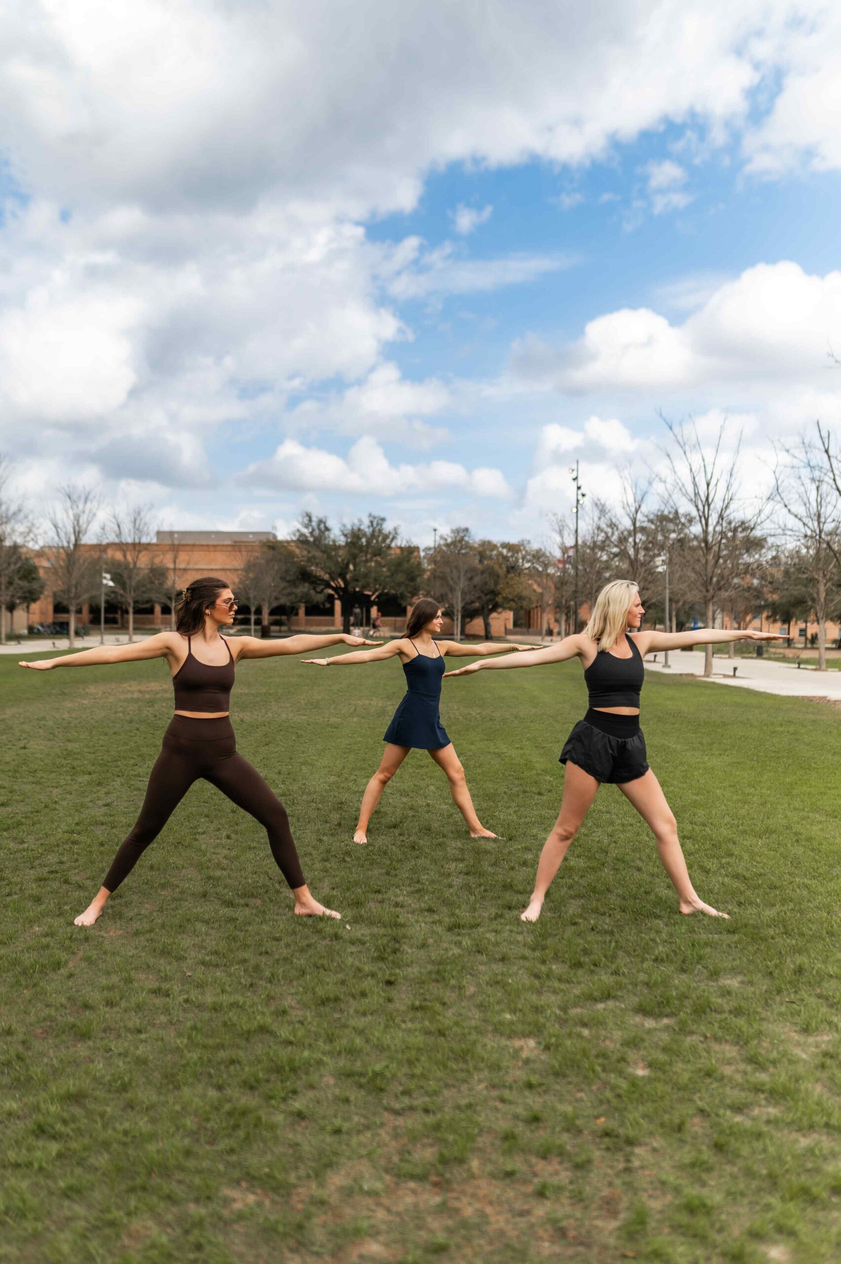 three women practicing yoga outdoors near honcho in college station tx scaled