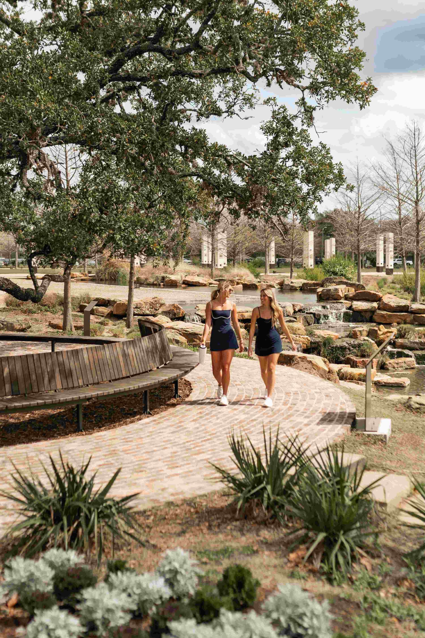 two women walking on park path at honcho in college station tx scaled